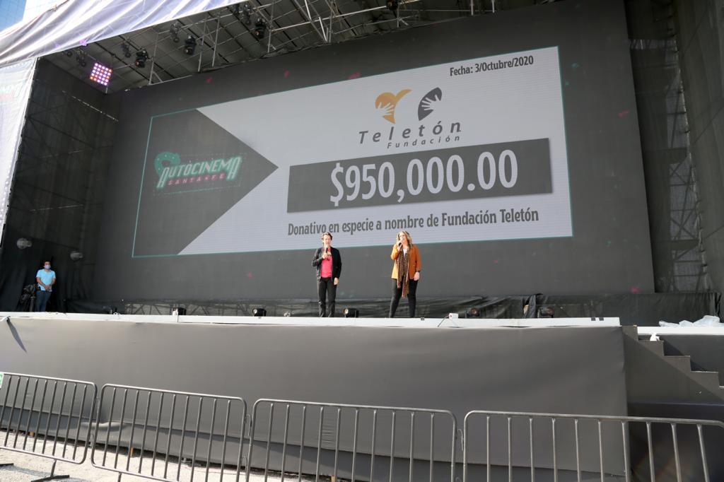 Foto de Fernando Landeros y Pamela Hamui, durante la función y el anuncio del donativo en el Autocinema Santa Fé