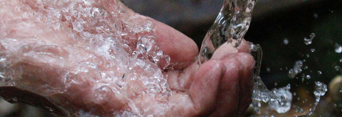Fotografía de una mano atrapando un chorro de agua. Foto por Samad Deldar para Pexels